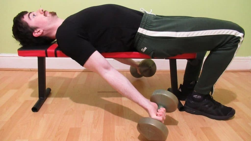 A man performing a lying dumbbell curl to work his biceps
