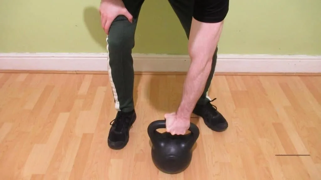 A man gripping a kettlebell