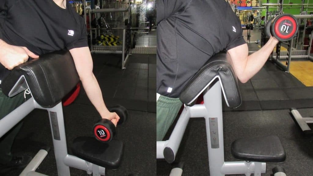 A man doing one arm dumbbell spider curls to work his biceps