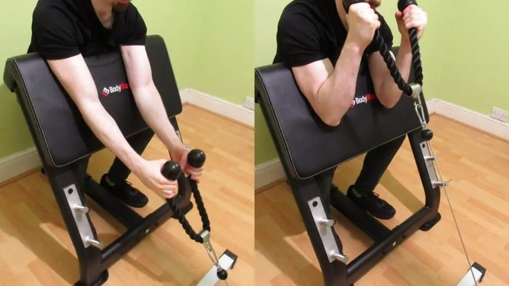 A man doing a preacher cable curl with a rope to work his biceps