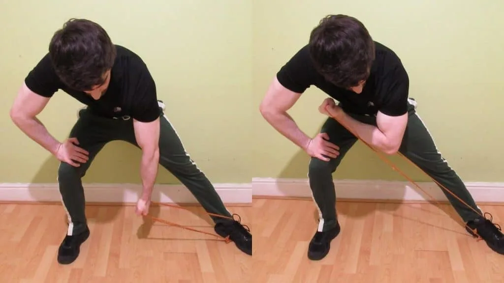 A man performing resistance band concentration curls for his biceps