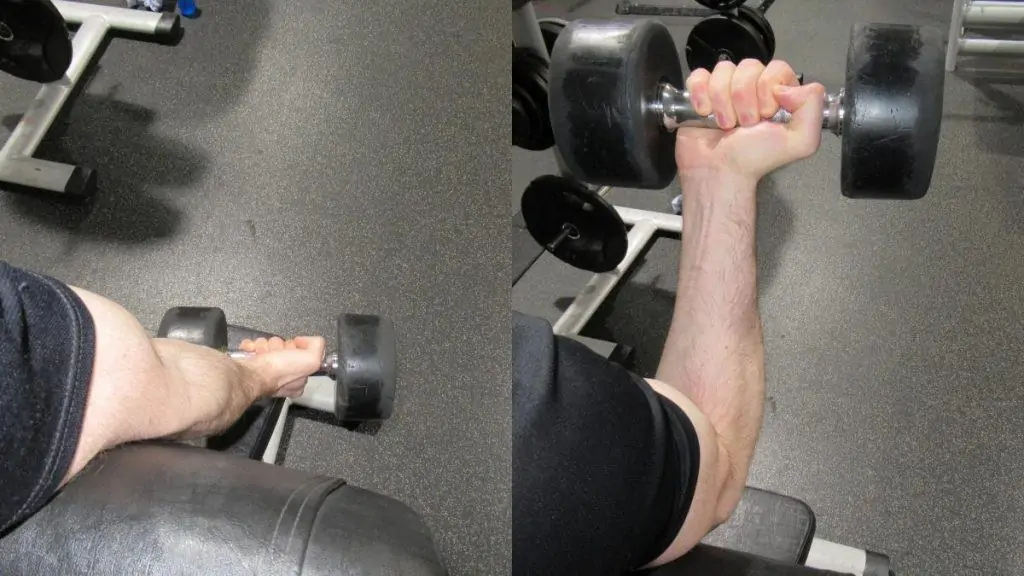 A man performing a single arm dumbbell spider curl with one weight