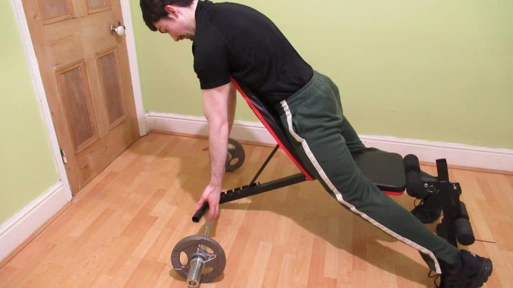 A man performing spider curls with an EZ bar