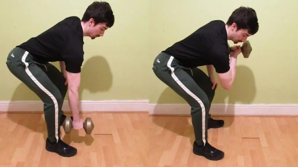 A man doing a standing dumbbell concentration curl for his biceps