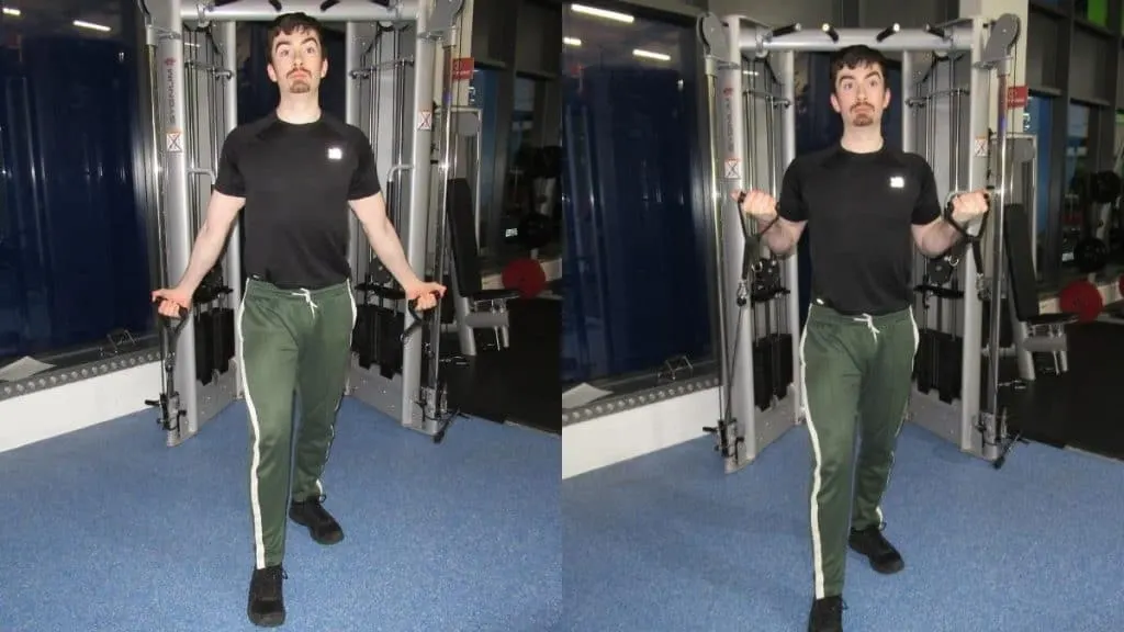 A man performing standing incline cable curls for his biceps