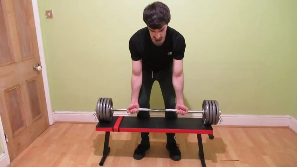 A man doing a strict curl for powerlifting