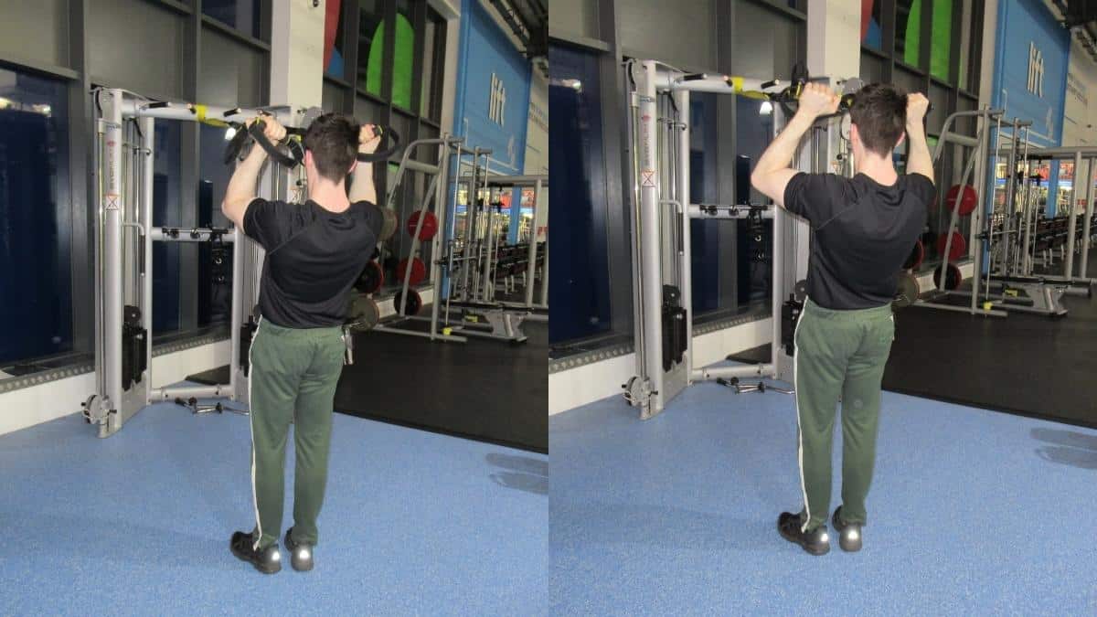 A man performing a TRX Zottman curl with a suspension trainer