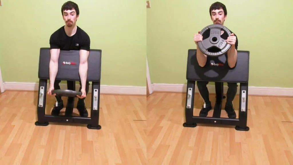 A man doing a weight plate preacher curl