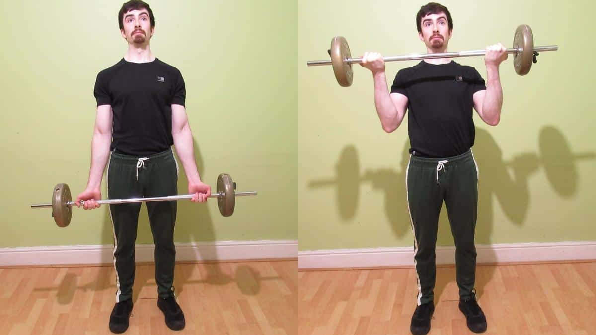 A man doing a standing wide grip barbell curl for his biceps