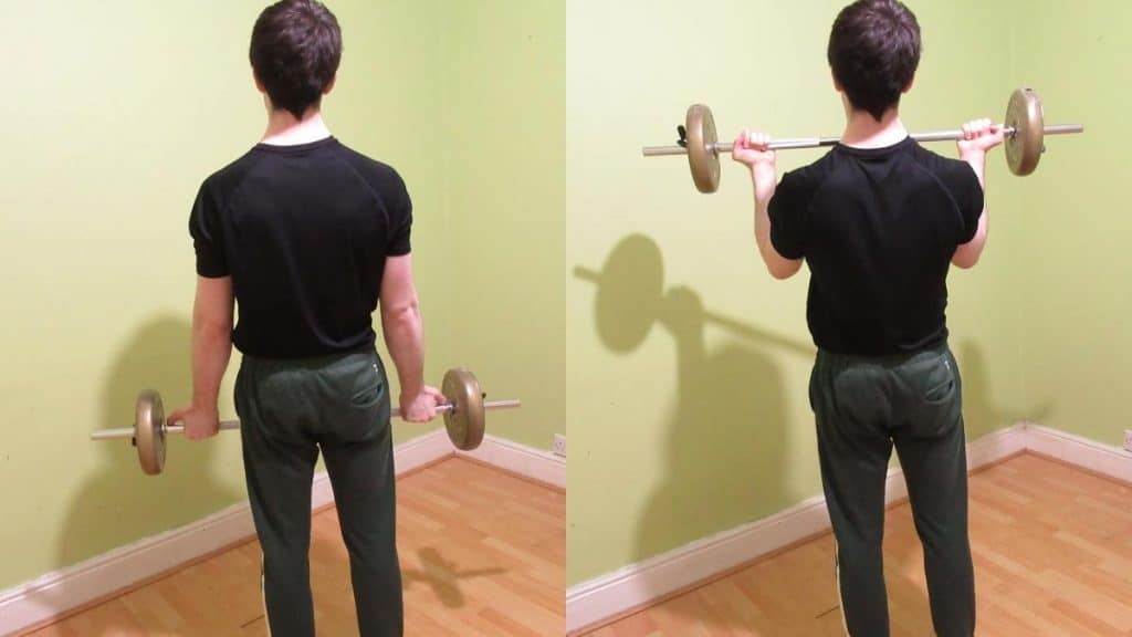 A man doing a wide grip standing barbell curl for his biceps