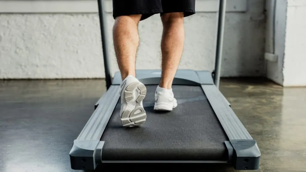 A man with a 13 inch calf circumference walking on the treadmill