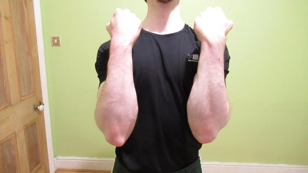A man showing what 13 inch forearms look like