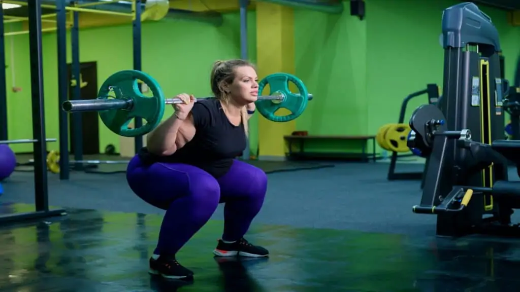 An obese woman training her 29 inch legs at the gym