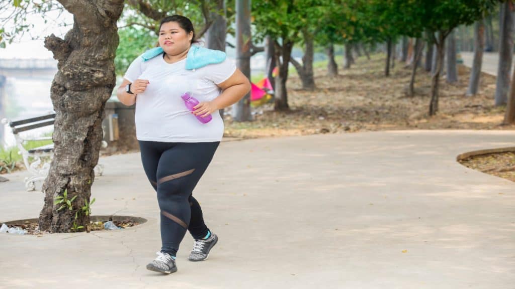 An obese woman with 50 inch thighs jogging outside
