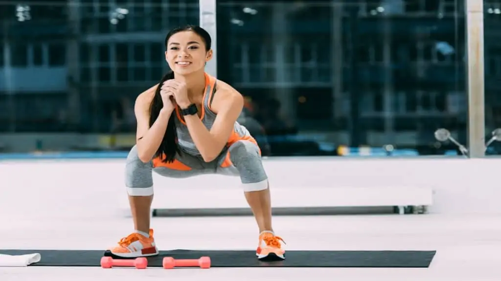 An asian woman doing squats