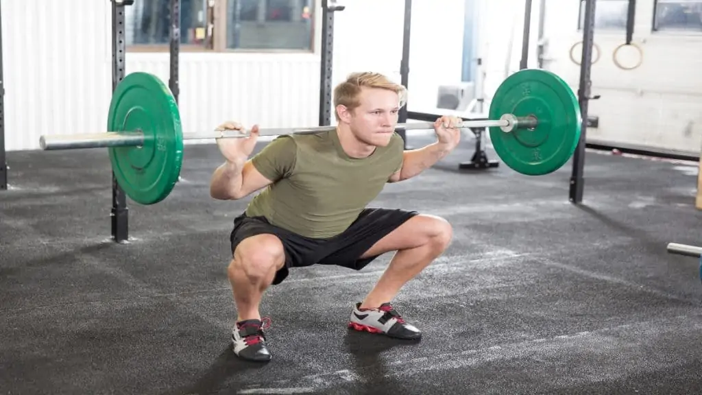 A man doing squats at the gym