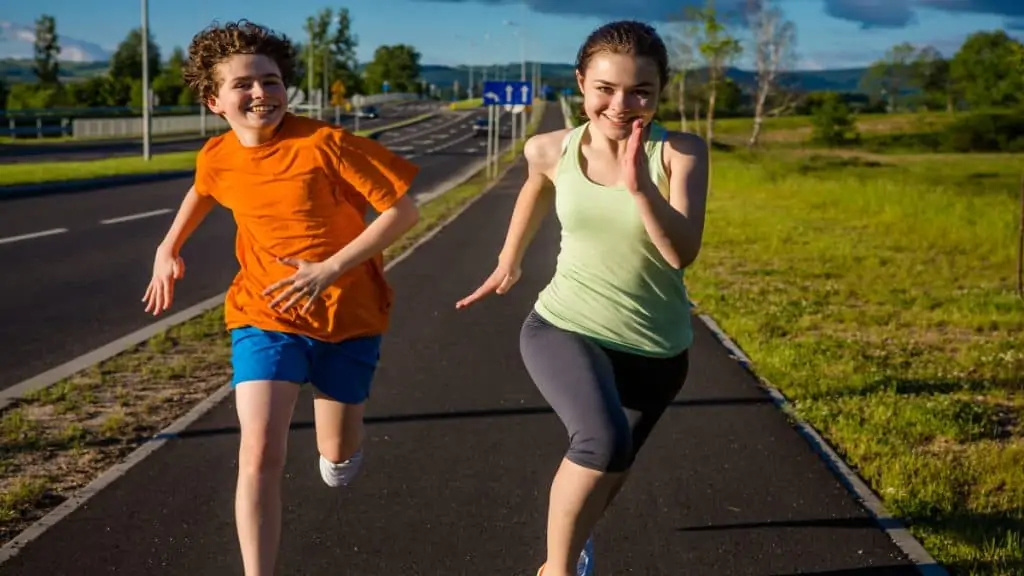 A boy and a girl running outside