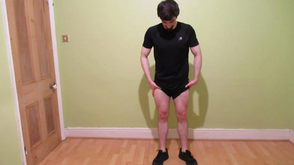 A man flexing his thighs and demonstrating that he has an average quad size