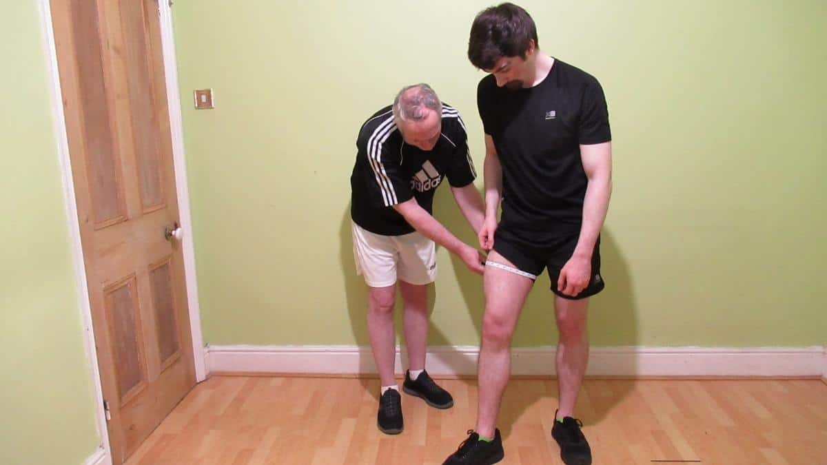 A man with an average thigh circumference getting his quads measured