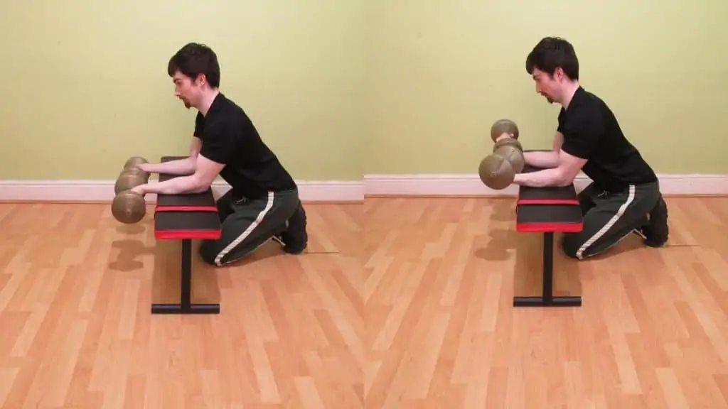 A man doing the dumbbell forearm curl exercise with his wrists over the bench