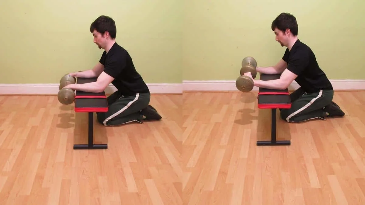 A man doing a dumbbell reverse wrist curl over a bench to work his forearms