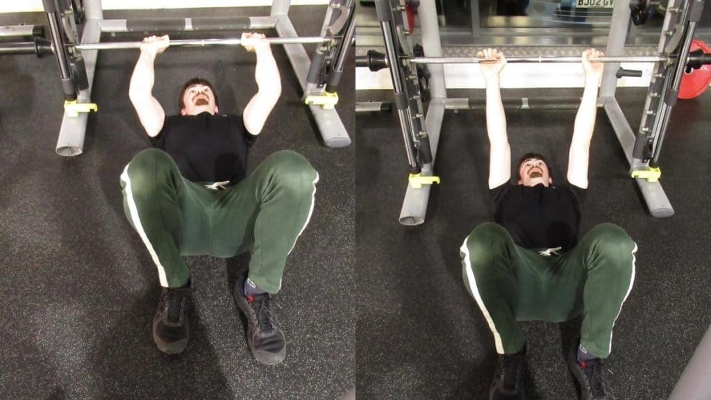 A man performing floor Smith machine skull crushers