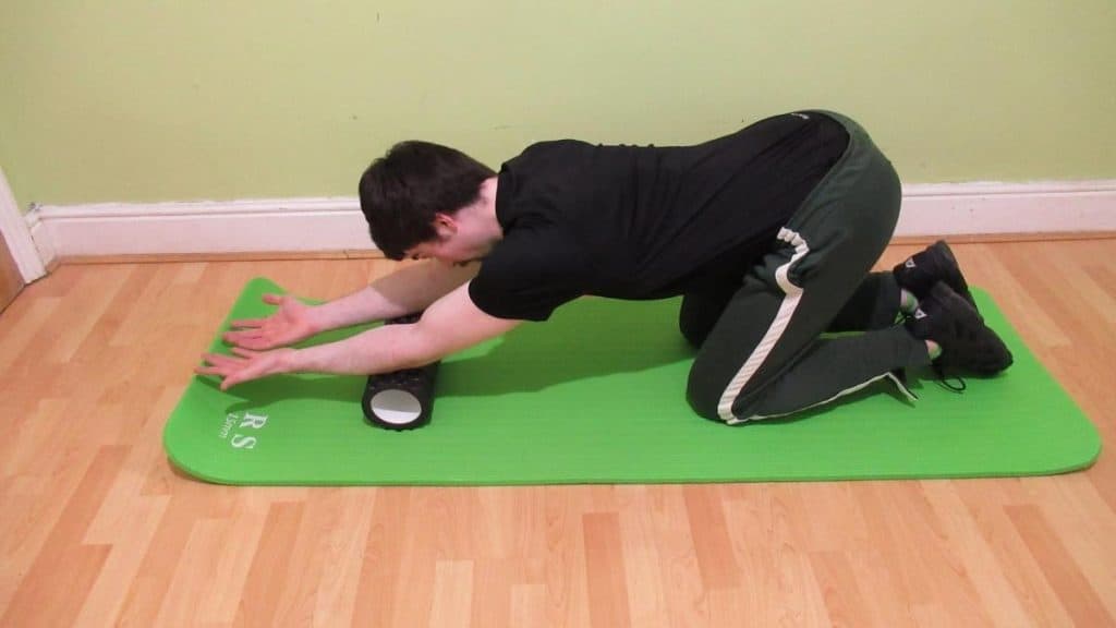 A man using a foam roller on his forearms