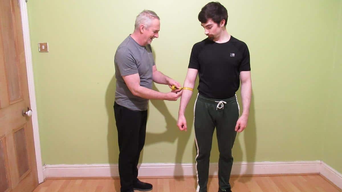A man having his forearm circumference measured to see if it's above average in size