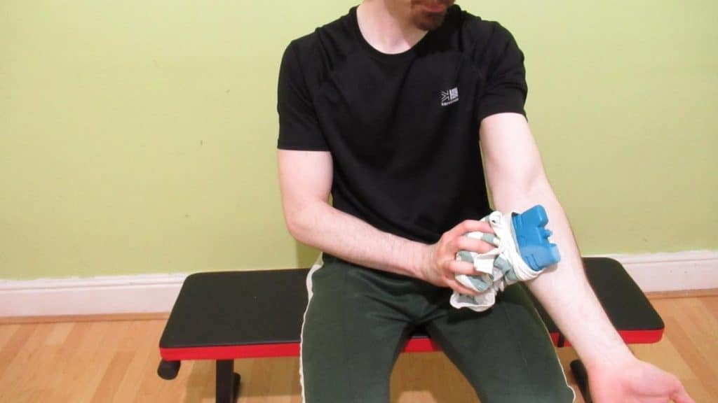 A man icing his lower arm due to having forearm muscle cramps