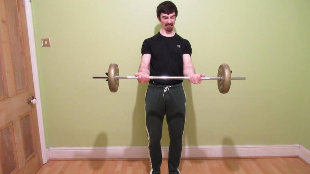 A man who clearly has forearm pain when lifting weights