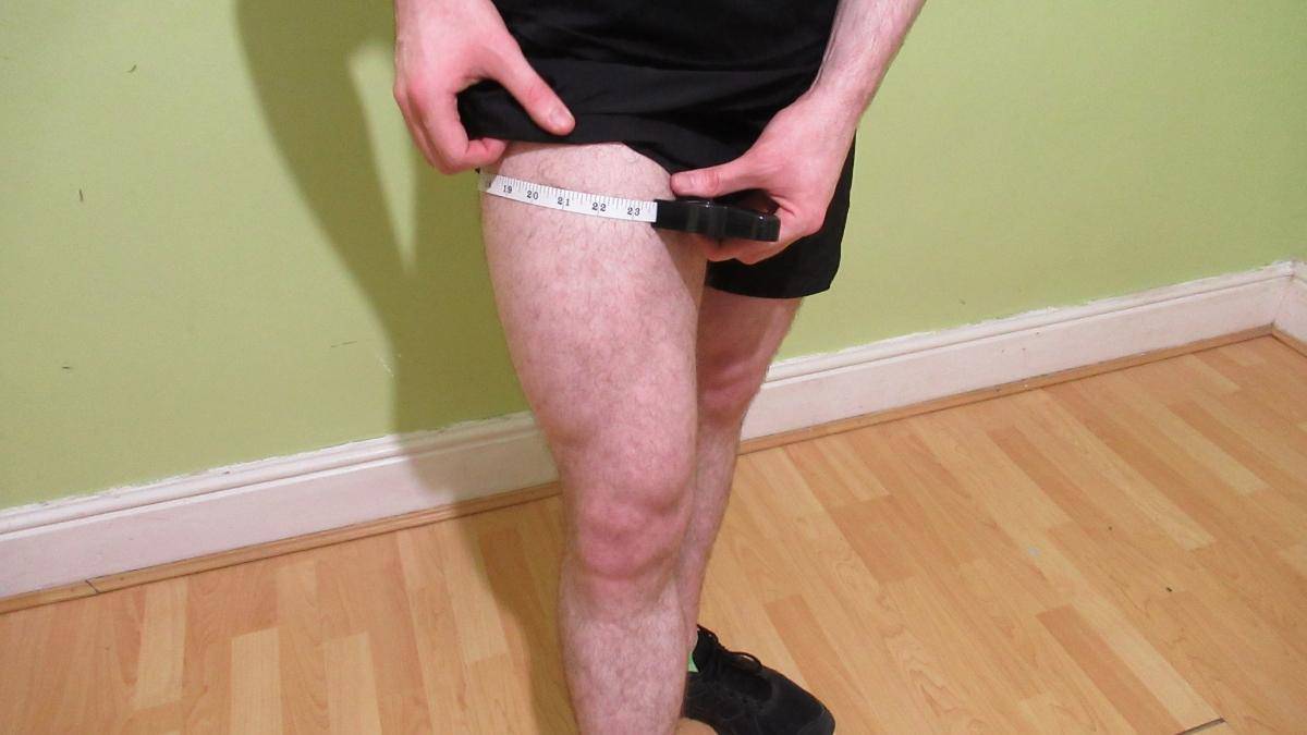 A man with muscular thighs showing how to measure your quads for bodybuilding