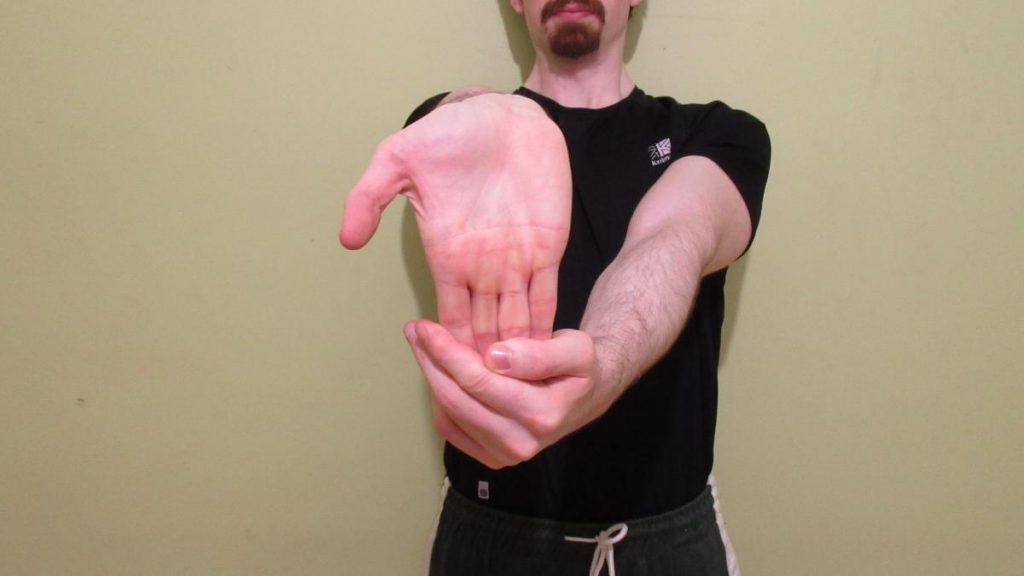 A man demonstrating how to stretch your forearm flexor muscles