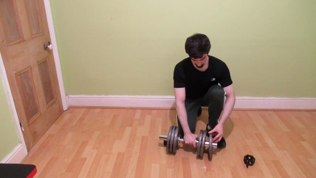 A man loading weights onto a dumbbell