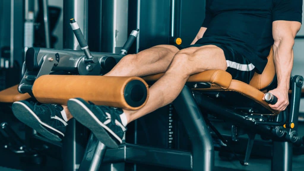 A man doing leg extensions at the gym
