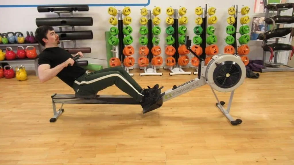 A man using a rowing machine at the gym