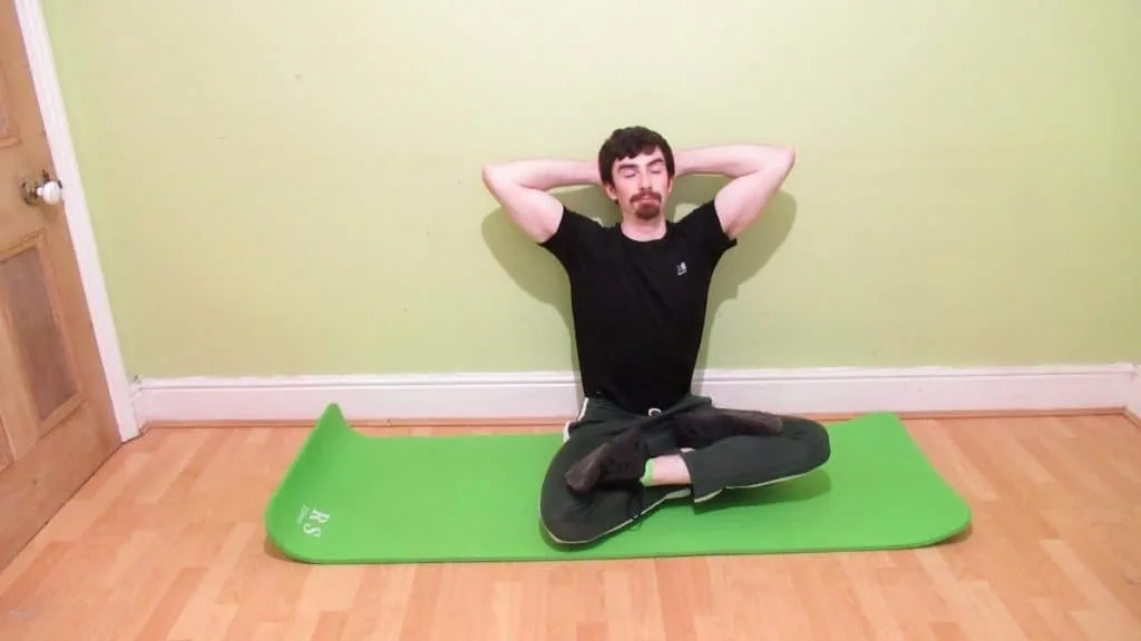 A man sitting on a yoga mat