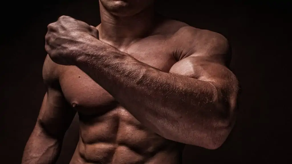 A huge bodybuilder showing his massive forearms