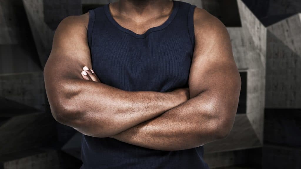 A muscular man folding his arms