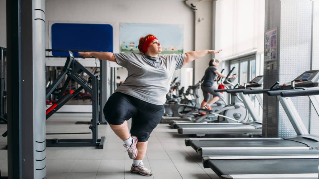An obese lady exercising in the gym