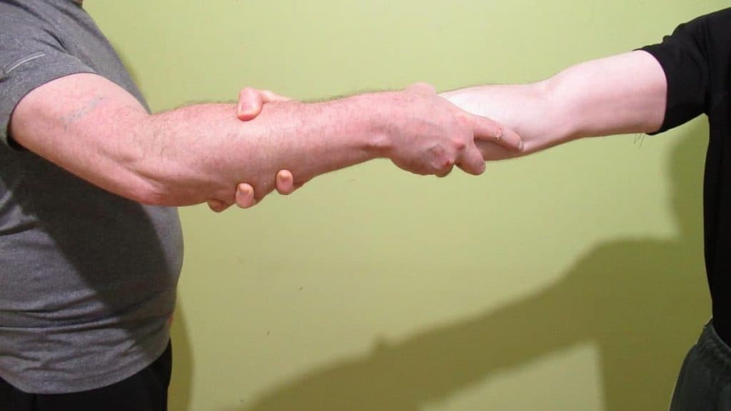 Two men using the Roman handshake (aka the forearm handshake)
