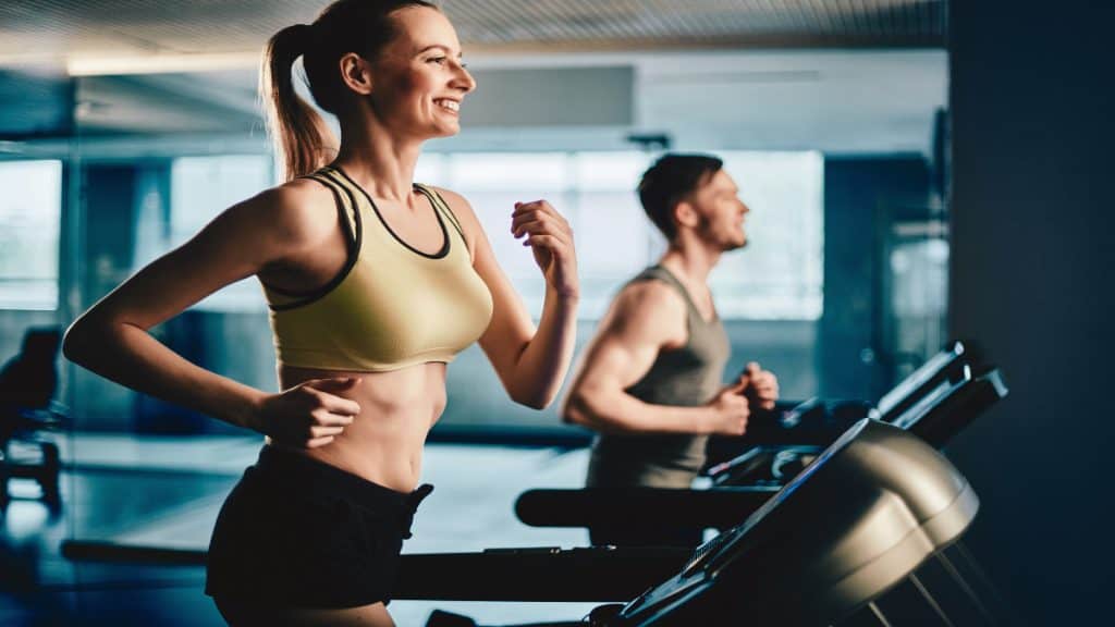 A smiling woman running on the treadmill