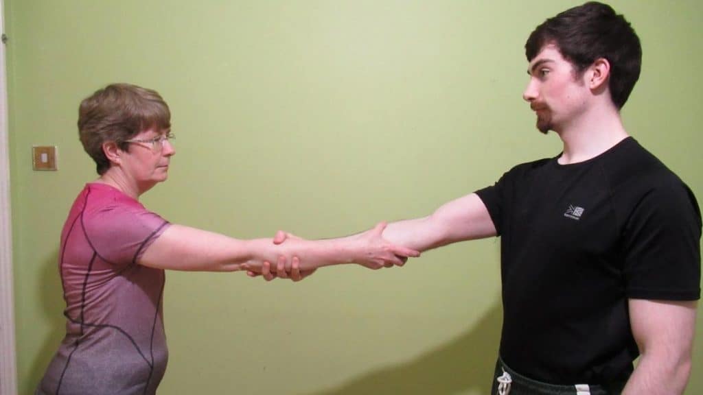 A man and a woman using the warrior handshake