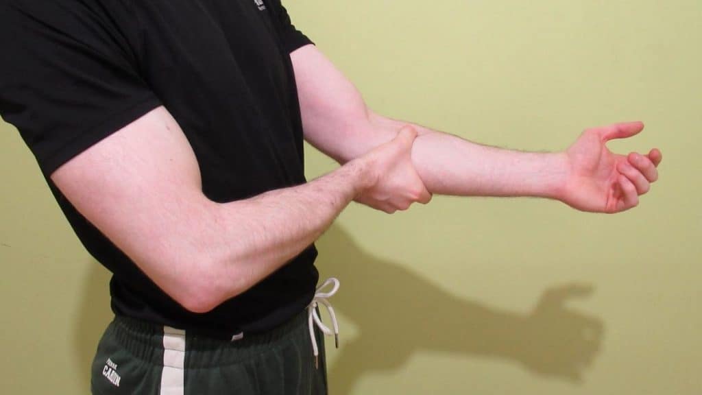 A man showing one of the most common weak forearms symptoms; pain in the muscle