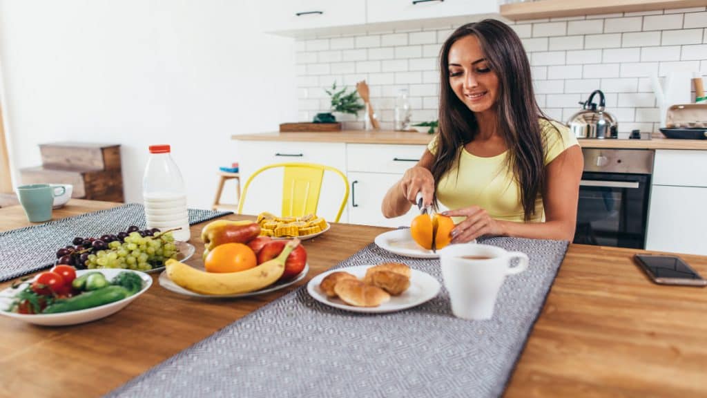 A woman eating a variety of food at the table