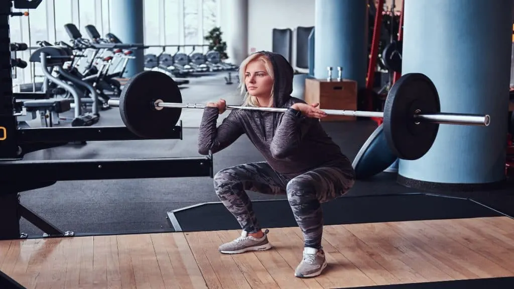 A woman doing squats in the gym