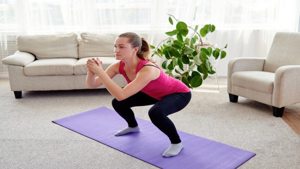 A woman doing squats in her living room