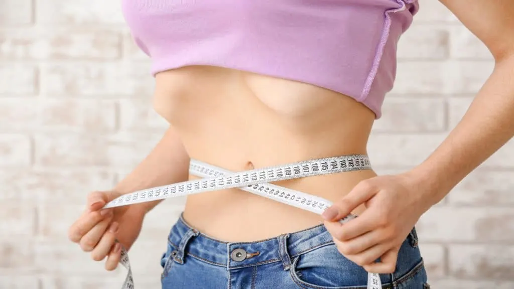 A lady measuring her 14.5 inch waist