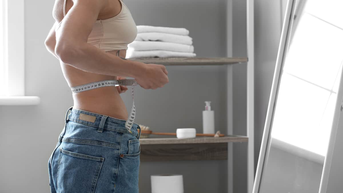 A woman measuring her slim 15 inch waist