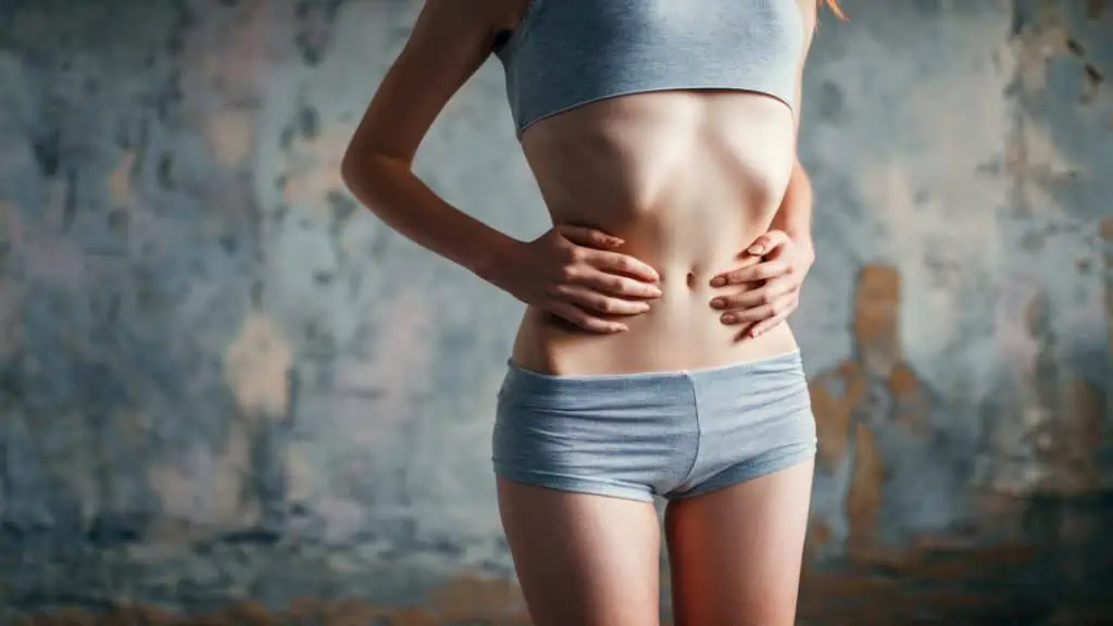 A woman holding her 21 in waist