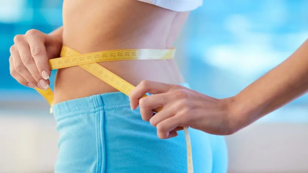 A woman measuring her 25.5 inch waist